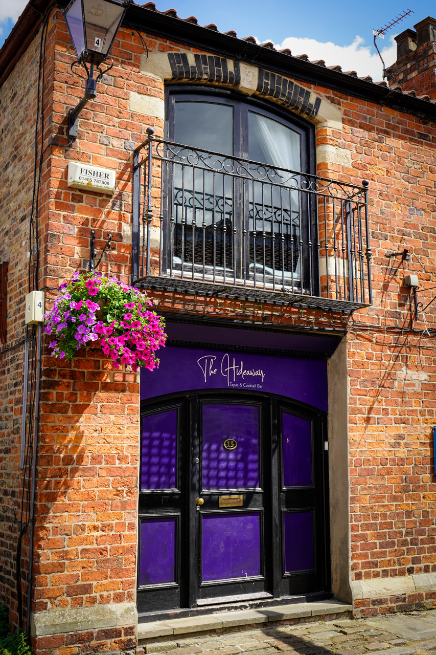 The Hideaway purple entrance door on the cobbles