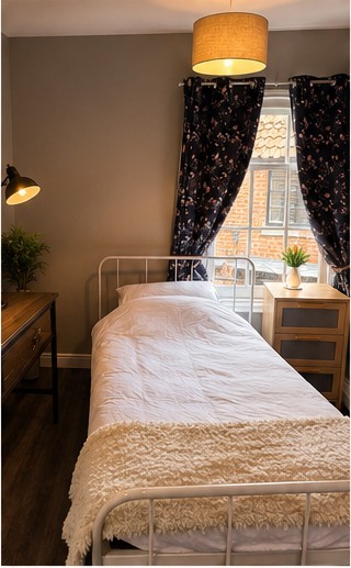 Single bedroom with iron bed frame and desk