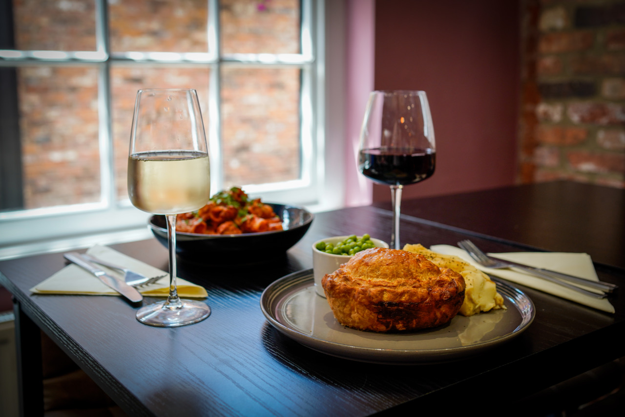 Pie and pasta by the window with a glass of wine