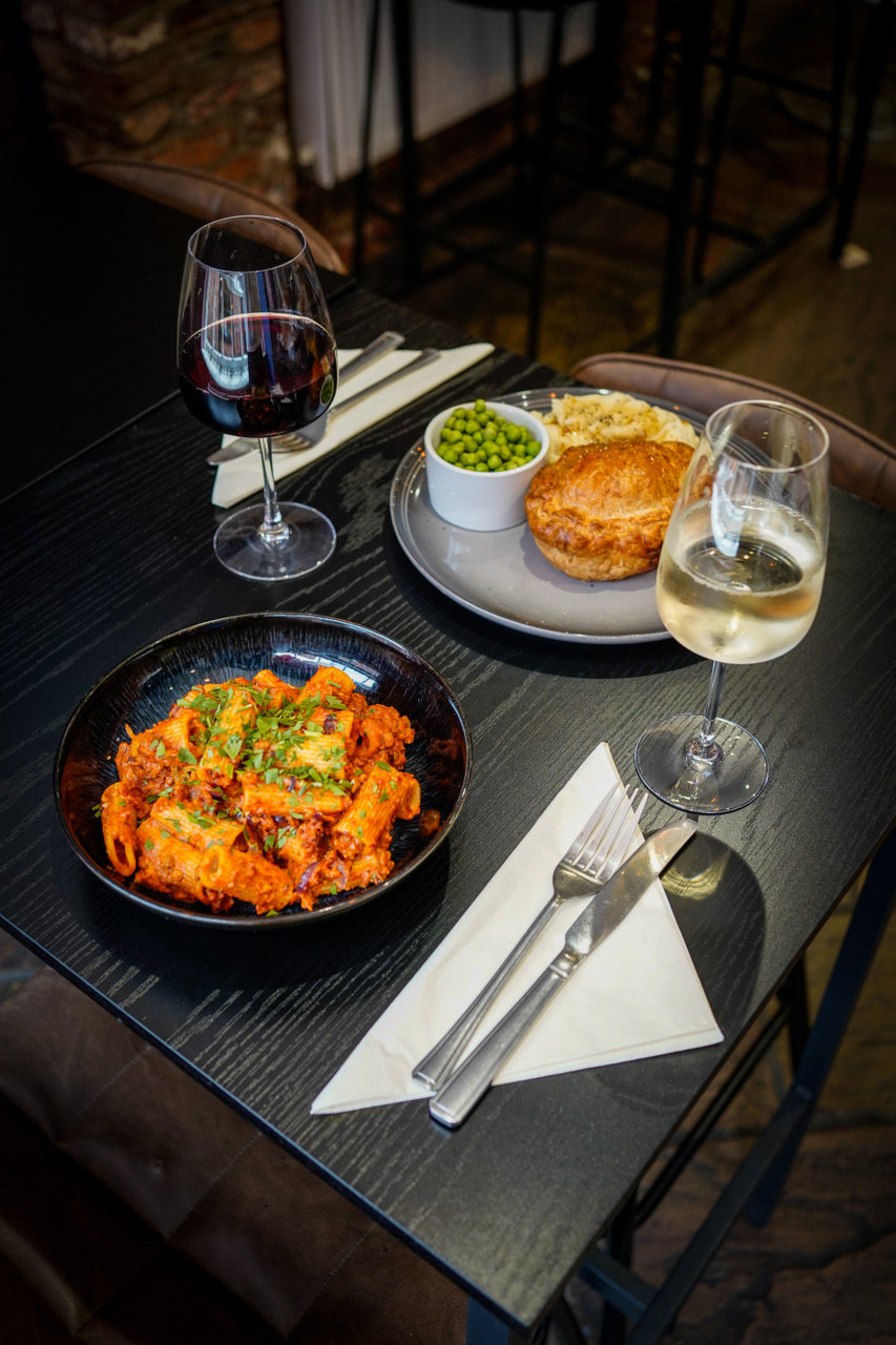 Pasta and pie with red and white wine set for two