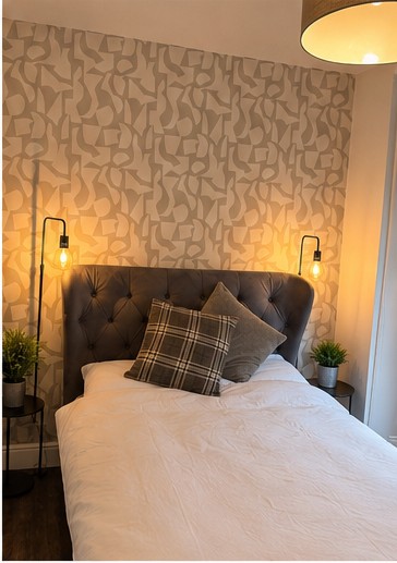 Double bedroom with buttoned headboard and patterned feature wall