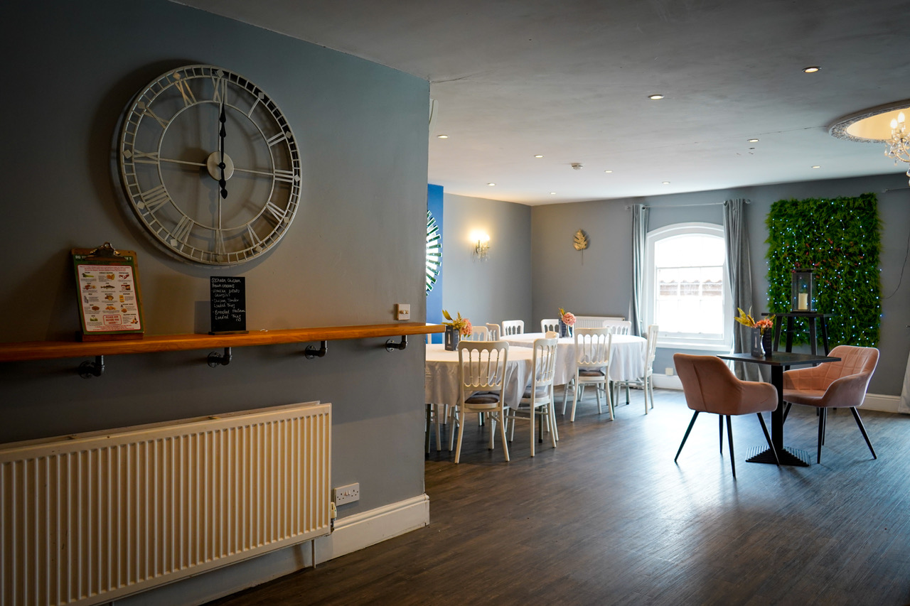 The Hideaway function room with clock and dressed tables