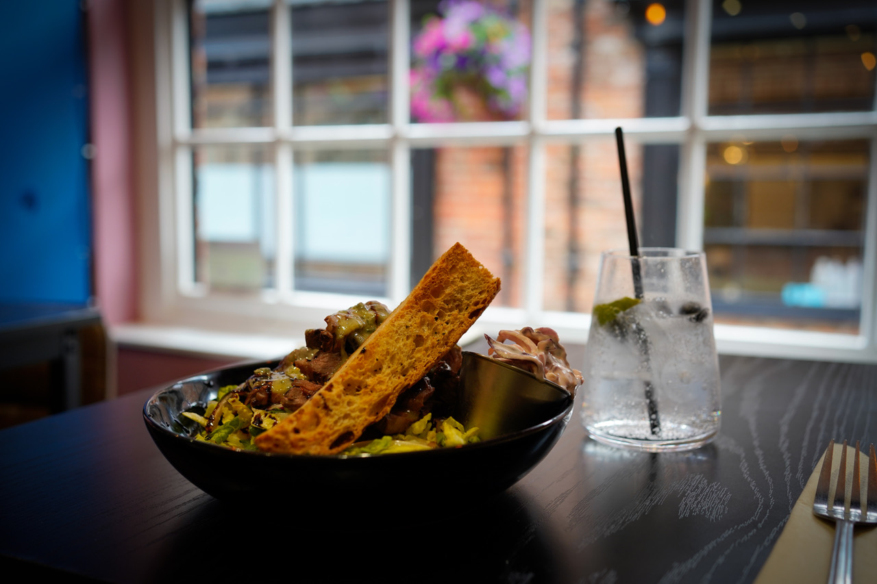 Small plate with toasted sourdough and a gin and tonic
